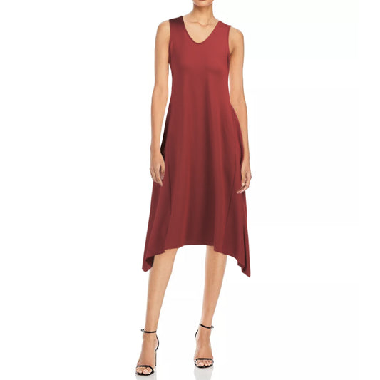 A model is wearing a red, sleeveless, V-neck, midi-length dress with a sharkbite hem design. The dress features two front pockets and is made of a stretchy fabric.